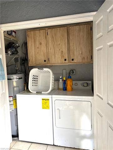 28230 Pine Haven Way, #68, Bonita Springs, FL 34135 Laundry area with water heater, cabinets, light tile patterned floors, and washing machine and clothes dryer