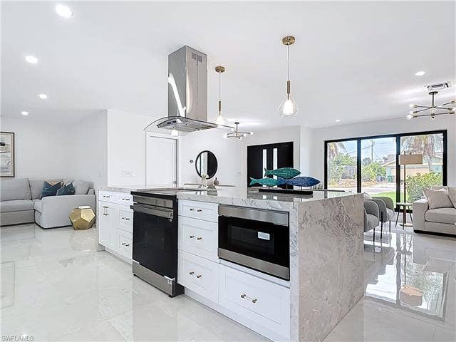 125 41st Ter, Cape Coral, FL 33904 Kitchen featuring open floor plan, stainless steel range with electric cooktop, ventilation hood, a chandelier, and recessed lighting