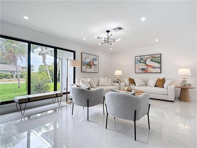 125 41st Ter, Cape Coral, FL 33904 Living room with recessed lighting, a chandelier, and light tile patterned floors