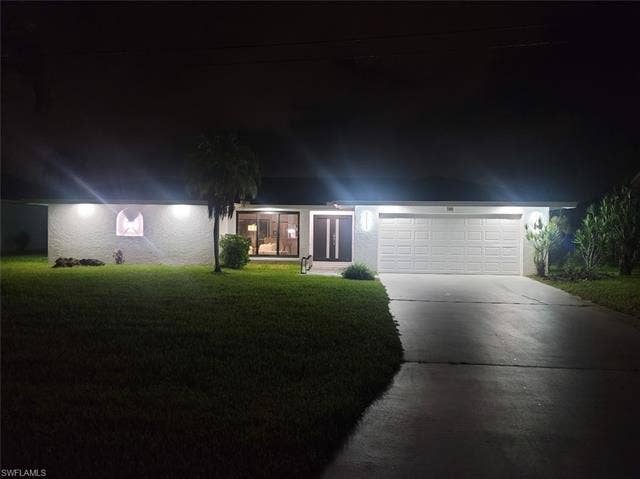 125 41st Ter, Cape Coral, FL 33904 View of front of home with driveway, a lawn, and a garage