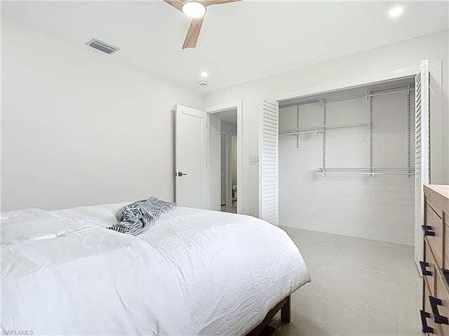 125 41st Ter, Cape Coral, FL 33904 Bedroom featuring a closet, a ceiling fan, baseboards, and concrete floors