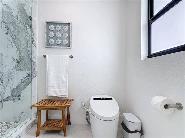 125 41st Ter, Cape Coral, FL 33904 Full bathroom with a walk in shower and toilet