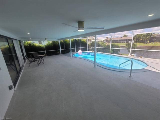 125 41st Ter, Cape Coral, FL 33904 View of pool featuring a lanai, a sunroom, a patio area, and a ceiling fan