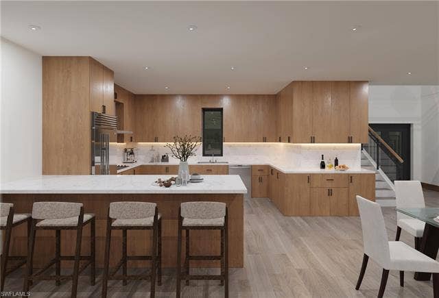437 Heathwood Dr, Marco Island, FL 34145 Kitchen with a peninsula, stainless steel appliances, a kitchen breakfast bar, backsplash, and light wood-style floors
