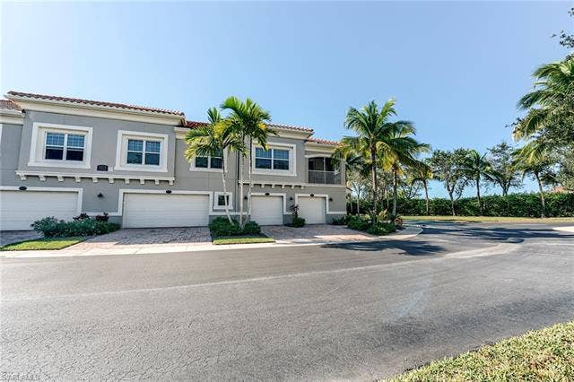8510 Violeta St, #203, Estero, FL 34135 Mediterranean / spanish-style home with stucco siding, a tile roof, driveway, and an attached garage