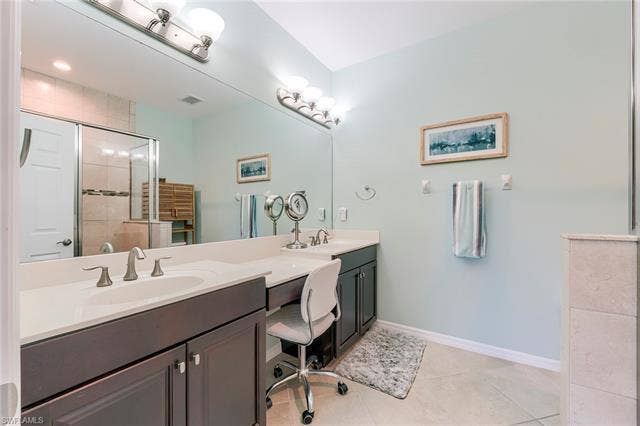 8510 Violeta St, #203, Estero, FL 34135 Bathroom featuring a shower stall, double vanity, and light tile patterned floors