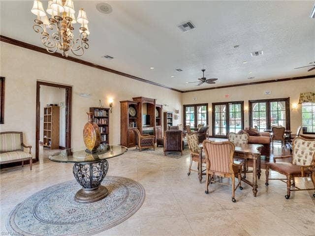 8510 Violeta St, #203, Estero, FL 34135 Dining room featuring ornamental molding, ceiling fan, and a chandelier