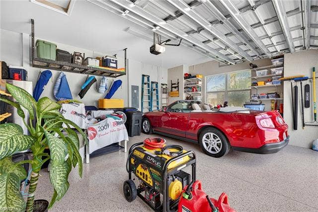 16717 Gilroy St, Bonita Springs, FL 34135 Garage features overhead storage, shelves with hanging brackets, a portable generator, and is oversized.