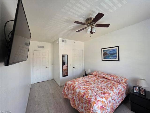 10127 Villagio Palms Way, #203, Estero, FL 33928 Bedroom with wood finished floors and a ceiling fan