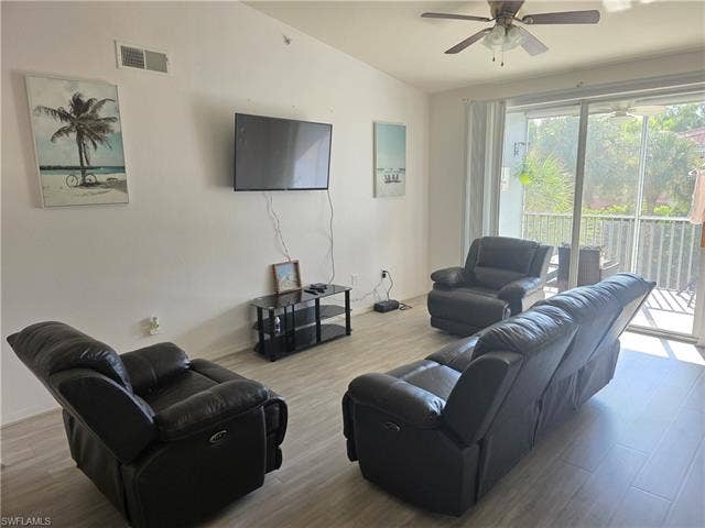 10127 Villagio Palms Way, #203, Estero, FL 33928 Living room with wood finished floors, a ceiling fan, and vaulted ceiling