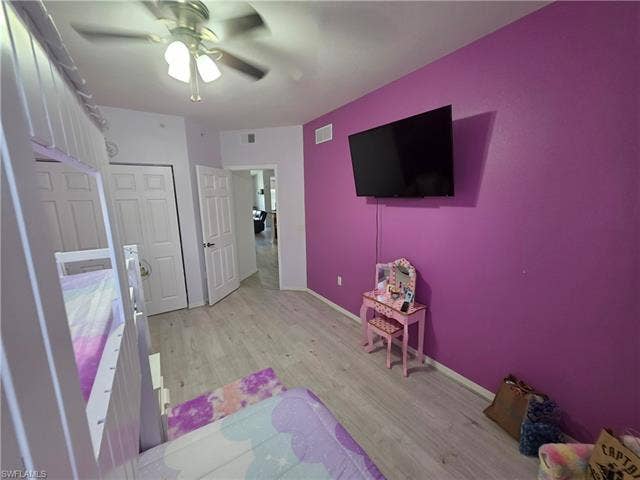 10127 Villagio Palms Way, #203, Estero, FL 33928 Bedroom with light wood-type flooring, a ceiling fan, and a closet