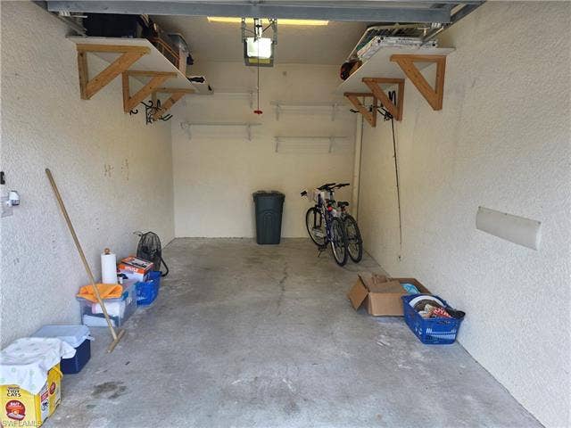 10127 Villagio Palms Way, #203, Estero, FL 33928 Garage featuring a textured wall and a garage door opener