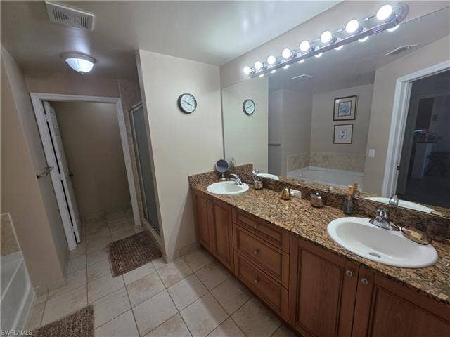 10127 Villagio Palms Way, #203, Estero, FL 33928 Full bathroom with a garden tub, double vanity, light tile patterned floors, and a shower stall