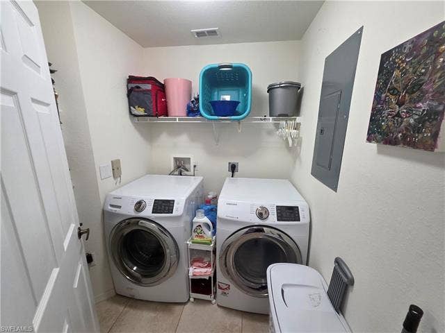 10127 Villagio Palms Way, #203, Estero, FL 33928 Washroom with light tile patterned floors, washer and clothes dryer, and electric panel