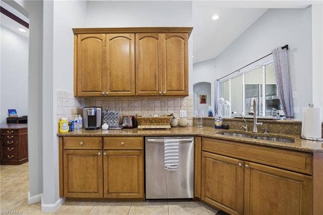 22140 Long Leaf Trail Dr, Estero, FL 34135 Kitchen with brown cabinetry, stainless steel dishwasher, light stone countertops, and recessed lighting