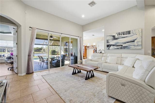 22140 Long Leaf Trail Dr, Estero, FL 34135 Living area with a sunroom, light tile patterned flooring, a water view, ceiling fan, and arched walkways