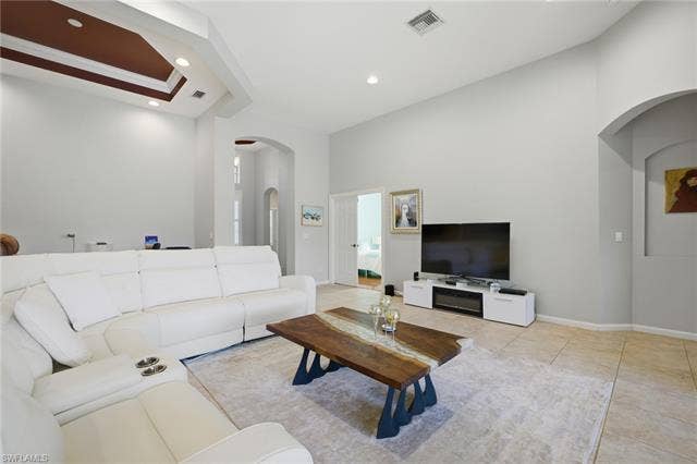 22140 Long Leaf Trail Dr, Estero, FL 34135 Living room featuring arched walkways, light tile patterned flooring, and recessed lighting