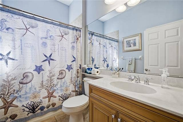 22140 Long Leaf Trail Dr, Estero, FL 34135 Bathroom with a shower with curtain, vanity, and light tile patterned floors