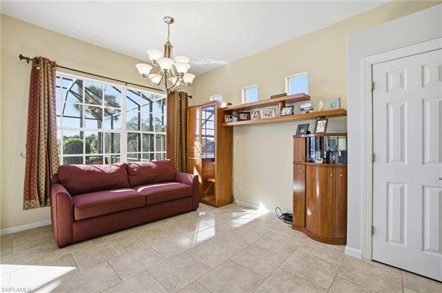 22140 Long Leaf Trail Dr, Estero, FL 34135 Living room featuring plenty of natural light, light tile patterned floors, and a chandelier