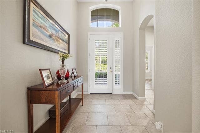 22140 Long Leaf Trail Dr, Estero, FL 34135 Entryway featuring arched walkways, a textured wall, and light tile patterned floors