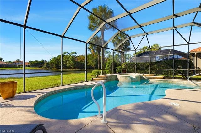 22140 Long Leaf Trail Dr, Estero, FL 34135 View of swimming pool with a lanai, a sunroom, a patio, a yard, and a water view