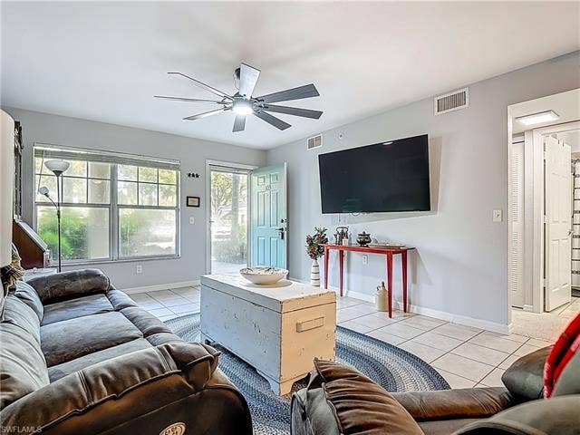 25735 Lake Amelia Way, #103, Bonita Springs, FL 34135 Living room featuring light tile patterned flooring and ceiling fan