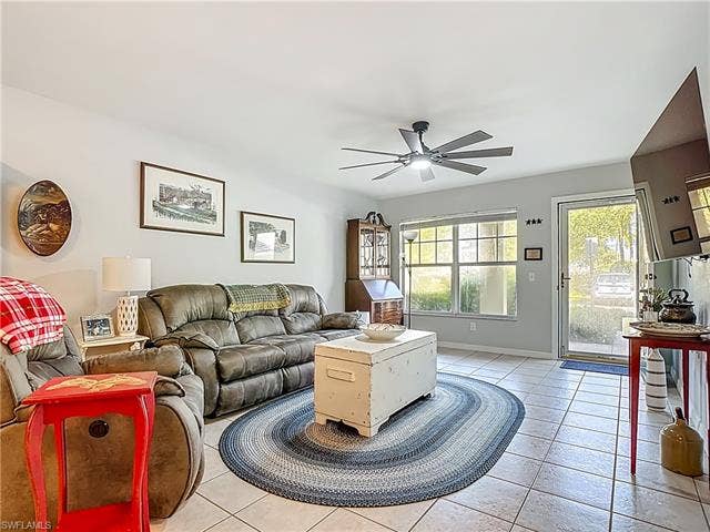 25735 Lake Amelia Way, #103, Bonita Springs, FL 34135 Living area with light tile patterned flooring and a ceiling fan