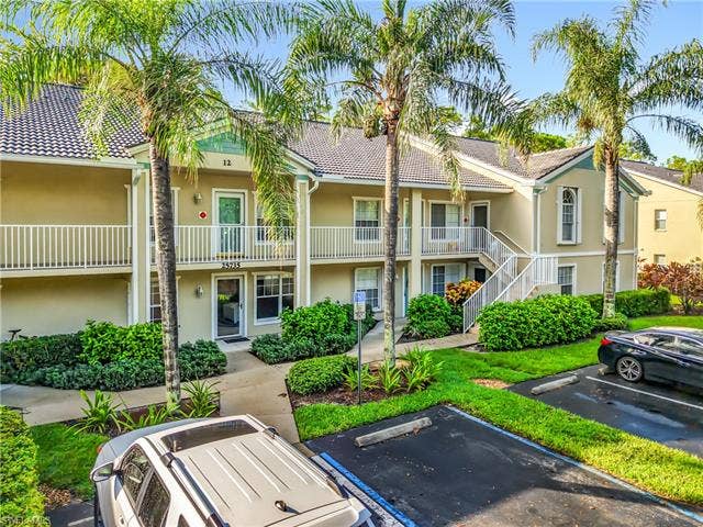 25735 Lake Amelia Way, #103, Bonita Springs, FL 34135 View of apartment building / complex featuring uncovered parking and stairway