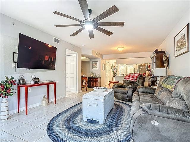 25735 Lake Amelia Way, #103, Bonita Springs, FL 34135 Living area with light tile patterned floors and ceiling fan