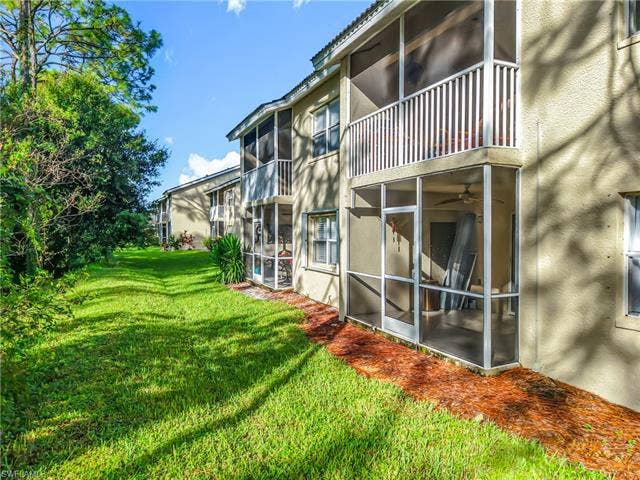 25735 Lake Amelia Way, #103, Bonita Springs, FL 34135 View of green lawn featuring a sunroom