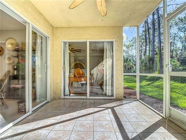 25735 Lake Amelia Way, #103, Bonita Springs, FL 34135 Unfurnished sunroom featuring a ceiling fan and a patio