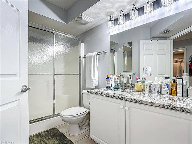 25735 Lake Amelia Way, #103, Bonita Springs, FL 34135 Bathroom featuring a stall shower, vanity, and light tile patterned flooring