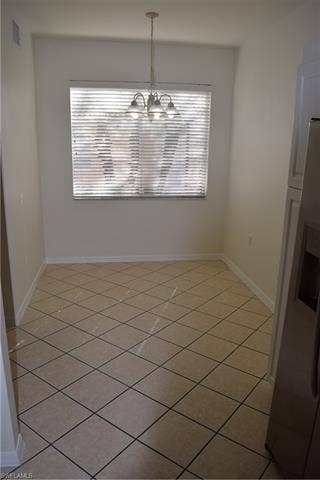 2350 Hidden Lake Ct, #8513, Naples, FL 34112 Unfurnished dining area with light tile patterned flooring and a chandelier