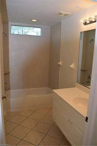 2350 Hidden Lake Ct, #8513, Naples, FL 34112 Bathroom featuring vanity, washtub / shower combination, and light tile patterned flooring