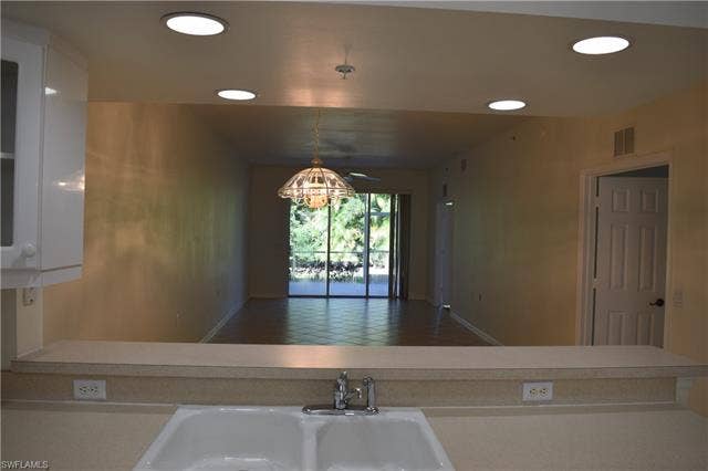 2350 Hidden Lake Ct, #8513, Naples, FL 34112 Kitchen featuring light countertops, hanging light fixtures, recessed lighting, white cabinets, and open floor plan
