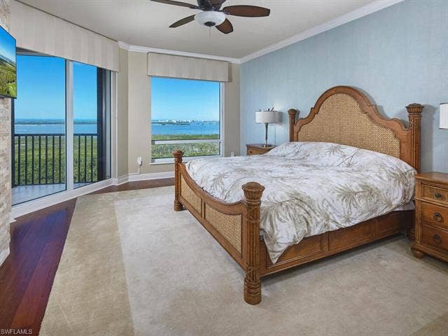 23750 Via Trevi Way, #2001, Estero, FL 34134 Bedroom featuring a water view, a ceiling fan, ornamental molding, and wood finished floors