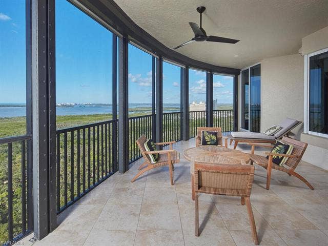 23750 Via Trevi Way, #2001, Estero, FL 34134 Sunroom featuring floor to ceiling windows, a water view, a textured ceiling, and tile patterned flooring