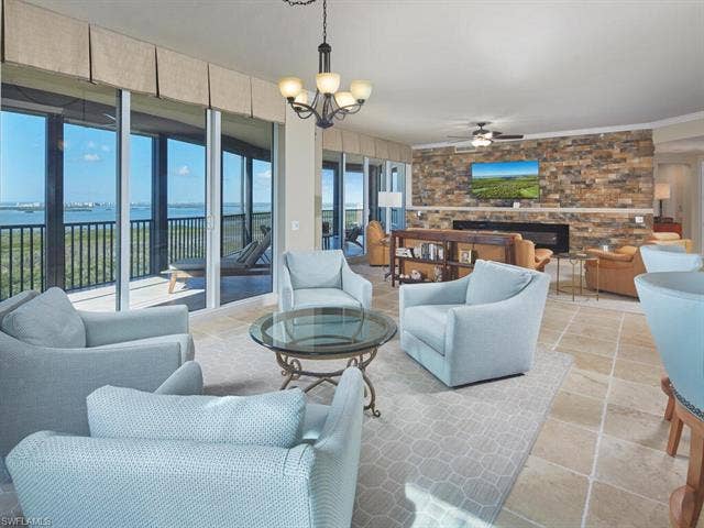 23750 Via Trevi Way, #2001, Estero, FL 34134 Living room with a chandelier, a water view, and ceiling fan