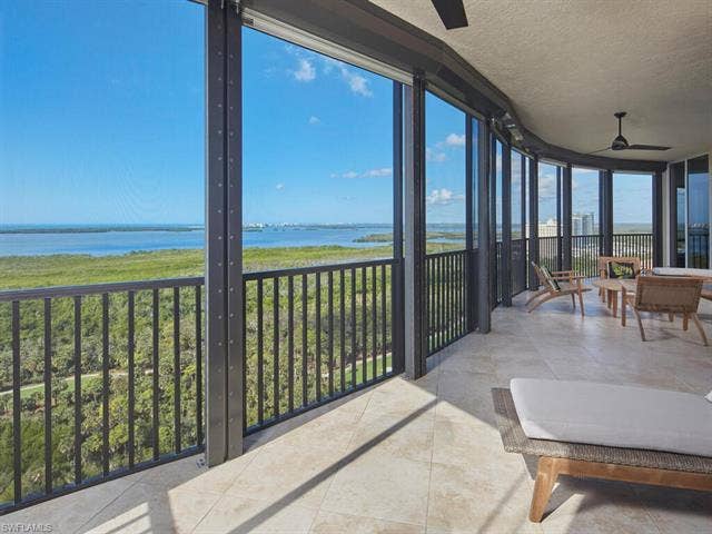23750 Via Trevi Way, #2001, Estero, FL 34134 Sunroom featuring a wall of windows, a water view, a textured ceiling, and tile patterned floors