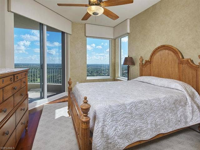23750 Via Trevi Way, #2001, Estero, FL 34134 Bedroom with ceiling fan, access to exterior, and dark wood-style flooring