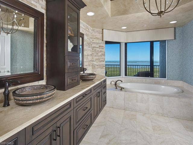23750 Via Trevi Way, #2001, Estero, FL 34134 Full bathroom with a chandelier, a bath, double vanity, and a water view