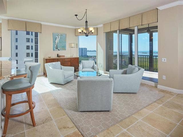 23750 Via Trevi Way, #2001, Estero, FL 34134 Living room featuring a chandelier, a water view, healthy amount of natural light, and crown molding
