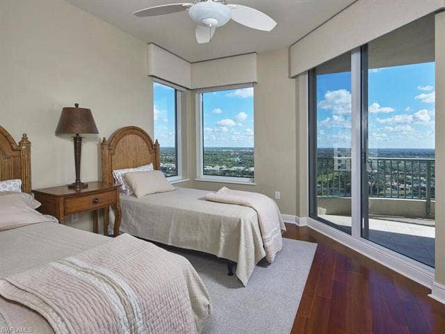 23750 Via Trevi Way, #2001, Estero, FL 34134 Bedroom with access to exterior, dark wood-style flooring, and a ceiling fan