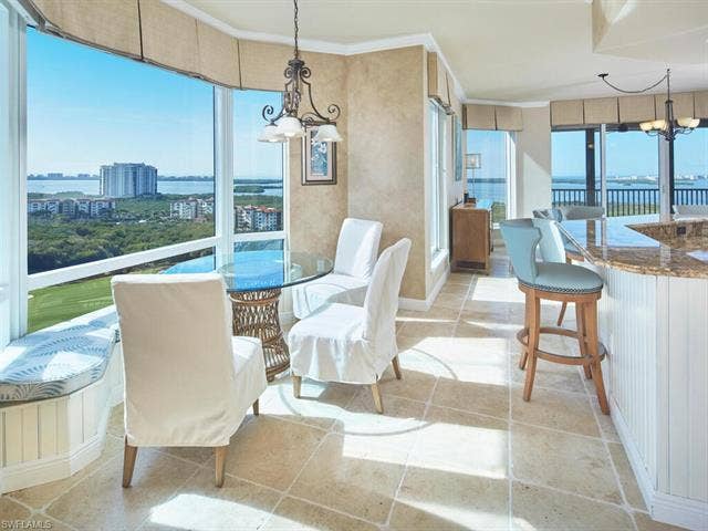23750 Via Trevi Way, #2001, Estero, FL 34134 Dining space with a chandelier, a water view, light tile patterned flooring, and ornamental molding