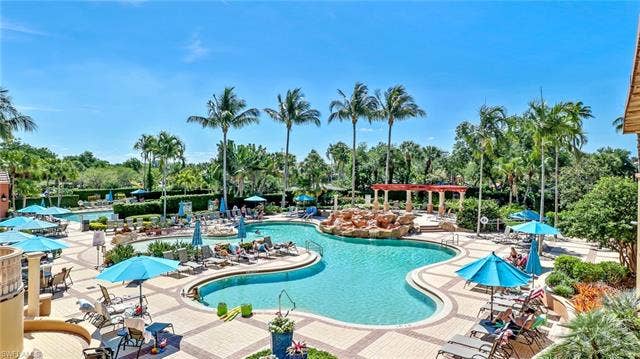 14546 Speranza Way, Bonita Springs, FL 34135 Community pool with a patio and view of wooded area