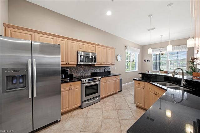 14546 Speranza Way, Bonita Springs, FL 34135 Kitchen with stainless steel appliances, light brown cabinetry, pendant lighting, light tile patterned flooring, and dark stone countertops