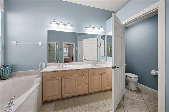 14546 Speranza Way, Bonita Springs, FL 34135 Full bath with double vanity, a garden tub, light tile patterned flooring, a shower stall, and ensuite bath