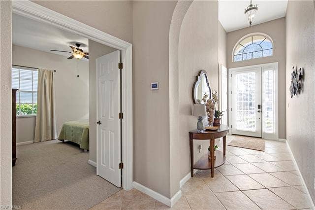14546 Speranza Way, Bonita Springs, FL 34135 Entrance foyer featuring light tile patterned flooring, arched walkways, and light carpet
