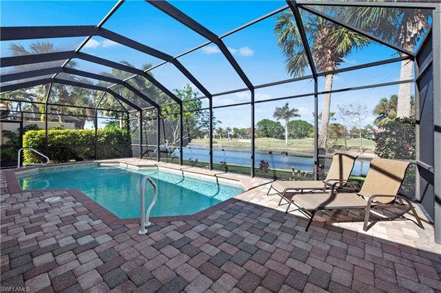 14546 Speranza Way, Bonita Springs, FL 34135 Swimming pool with a sunroom, a water view, a lanai, and a patio