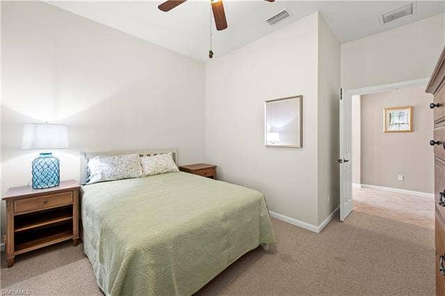 14546 Speranza Way, Bonita Springs, FL 34135 Bedroom with light colored carpet and ceiling fan